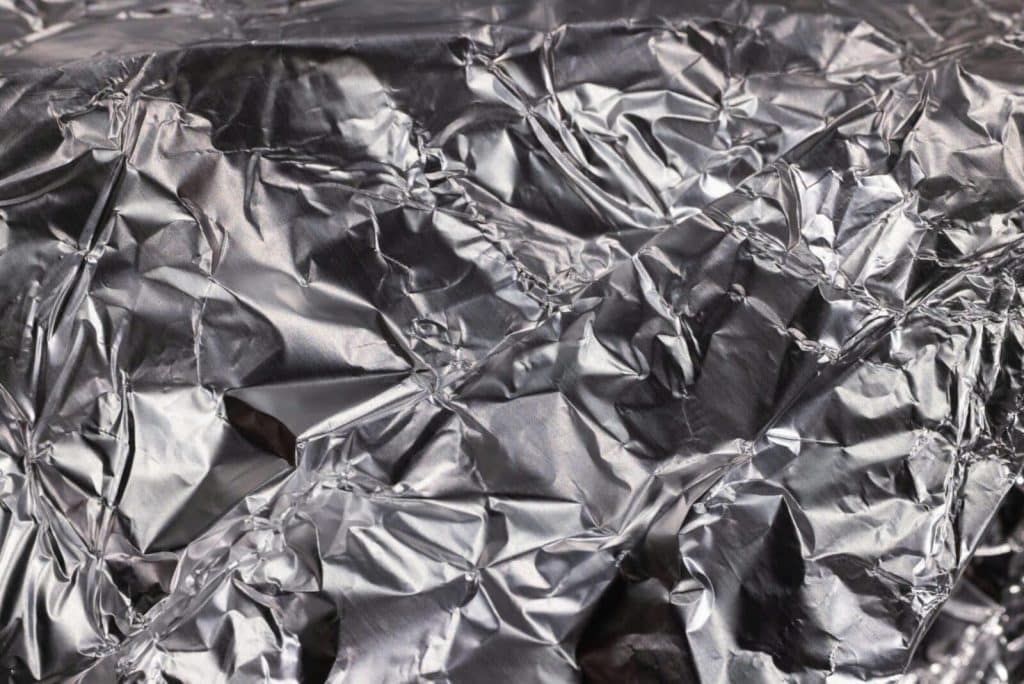 Close-up of shiny crumpled aluminum foil showcasing metallic wrinkled texture.