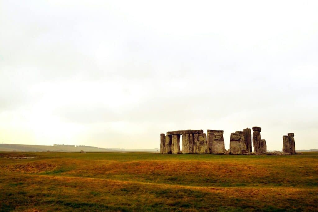 Explore the ancient mystery of Stonehenge set in a serene landscape under a bright sky.