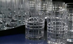 Close-up of elegant crystal drinking glasses with a geometric design, displaying intricate glasswork.