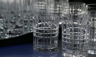 Close-up of elegant crystal drinking glasses with a geometric design, displaying intricate glasswork.