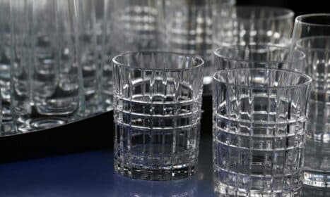 Close-up of elegant crystal drinking glasses with a geometric design, displaying intricate glasswork.
