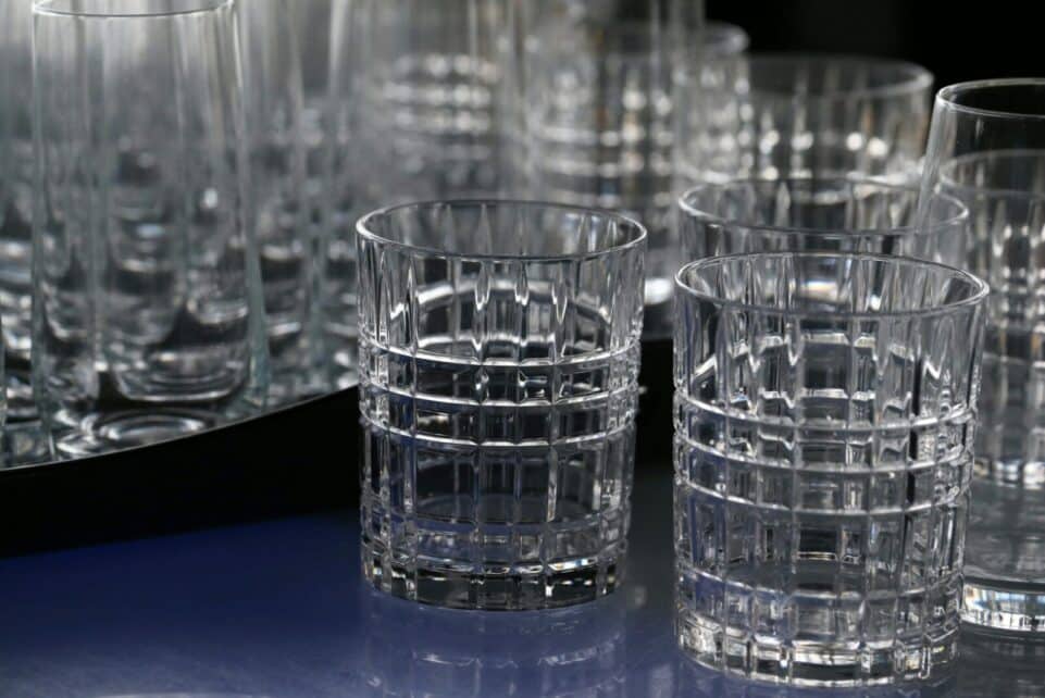 Close-up of elegant crystal drinking glasses with a geometric design, displaying intricate glasswork.