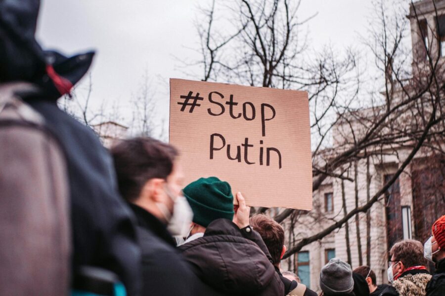 People in Berlin protest against Putin with anti-war signs, showing unity for peace.