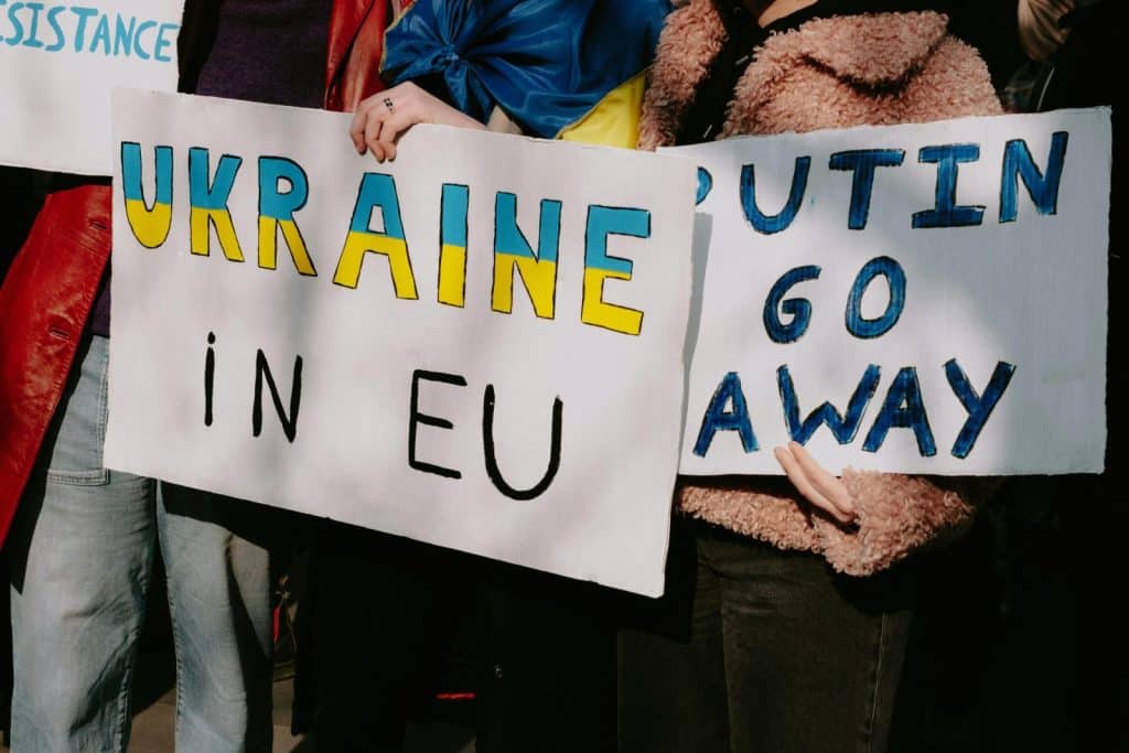 Protest with signs supporting Ukraine in EU and opposing Putin. Capturing a social movement outdoors.