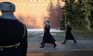 Ceremonial guards in winter uniforms march by Kremlin wall, Moscow.
