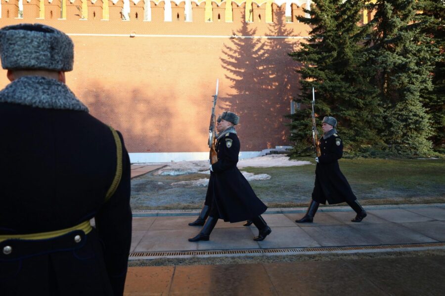 Ceremonial guards in winter uniforms march by Kremlin wall, Moscow.