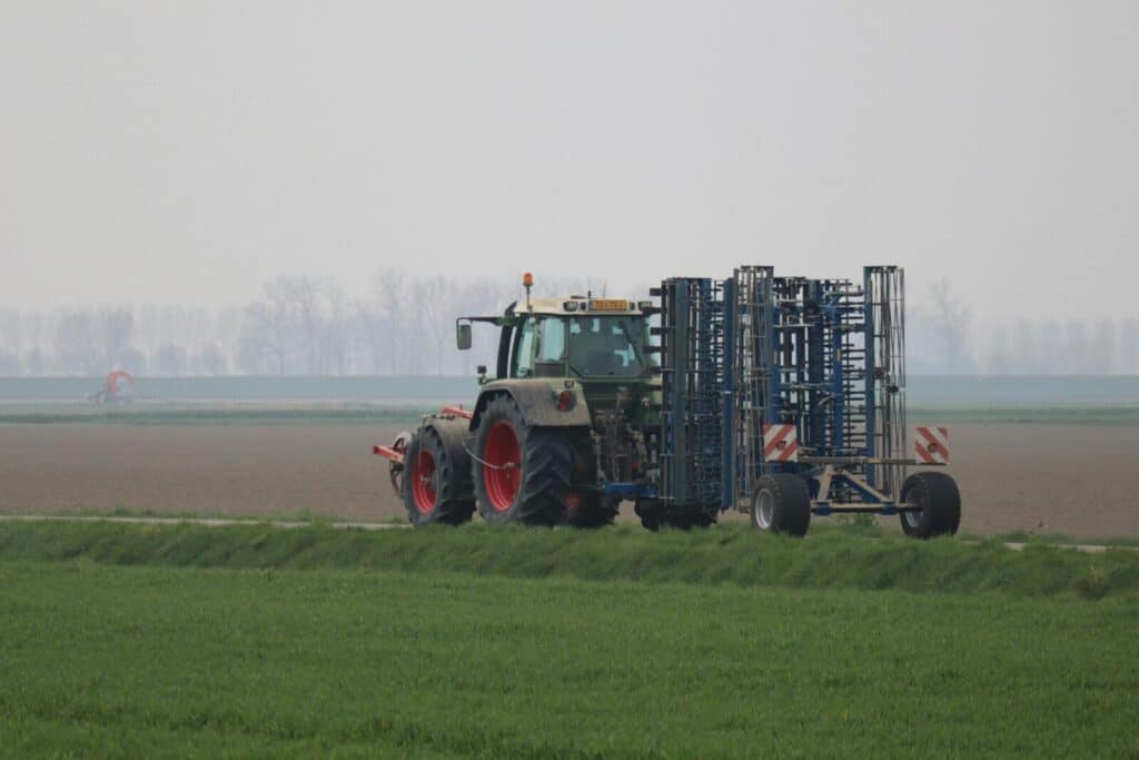 A tractor working on agricultural land during an overcast day, depicting modern farming practices.