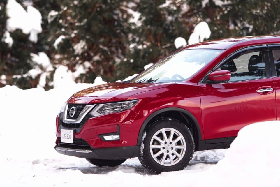 A red SUV parked on a snow-covered landscape during winter.