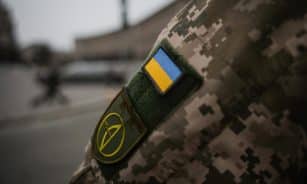 Detailed shot of Ukrainian military uniform with flag patch, symbolizing national pride.