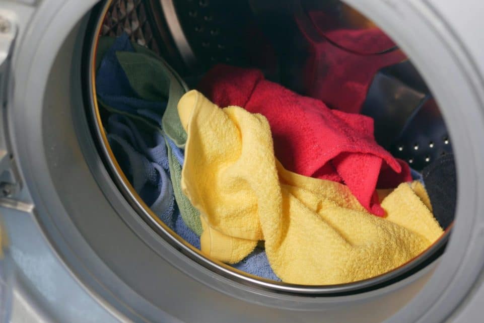 Vibrant close-up of multicolored towels inside a washing machine, ready for a wash.
