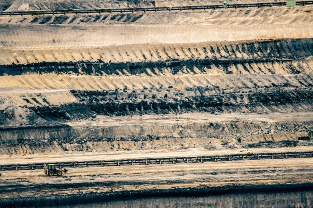Aerial view of an open-pit mine with excavator in Inden, Germany.