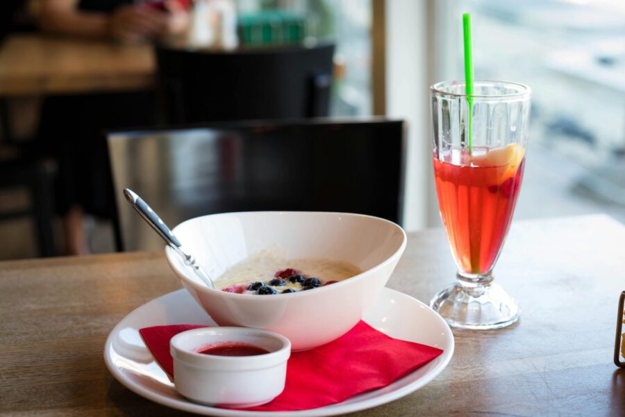Delightful breakfast setting with a bowl of porridge and colorful fruit juice in a café.