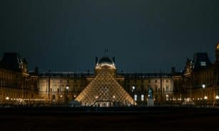 Discover the iconic Louvre Pyramid glowing against the Paris night sky.