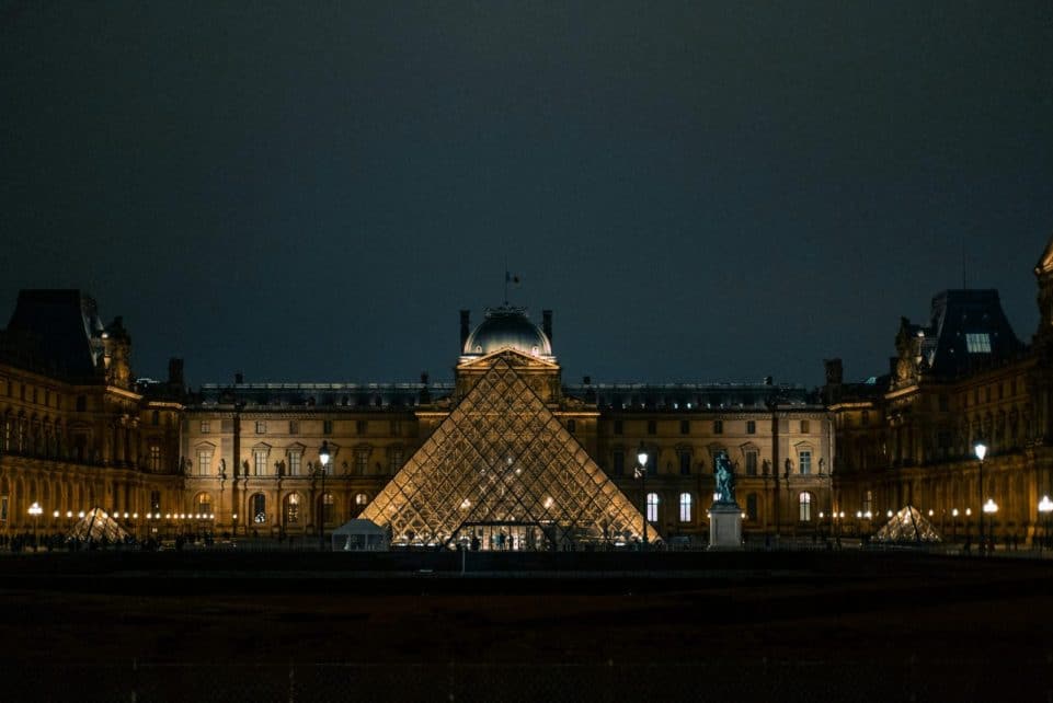 Discover the iconic Louvre Pyramid glowing against the Paris night sky.
