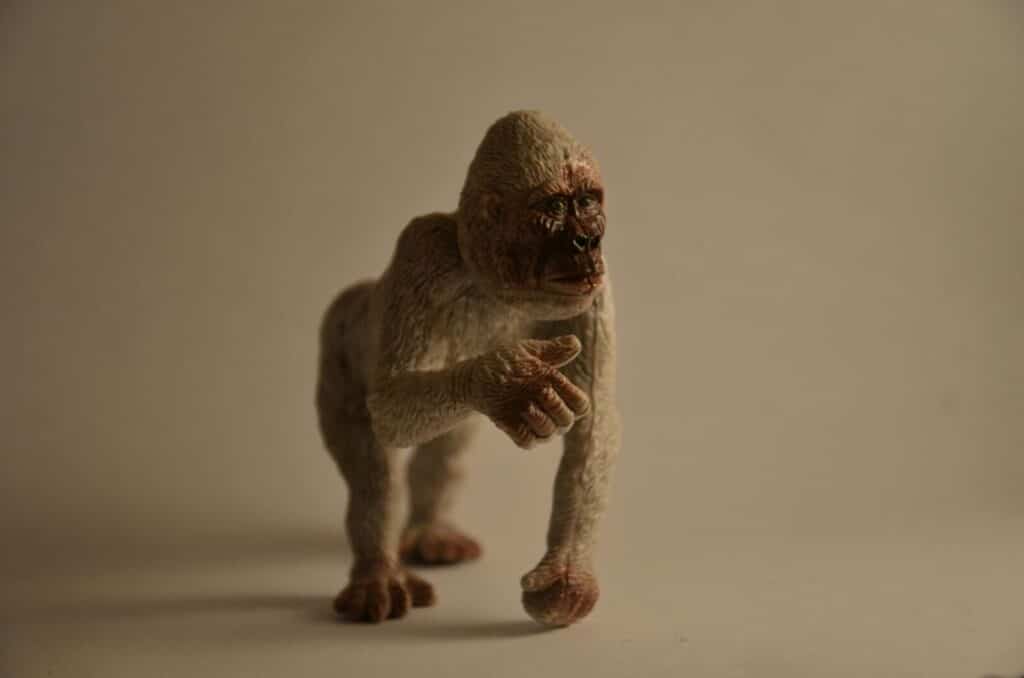 Detailed primate toy figure resembling a monkey captured in soft lighting.