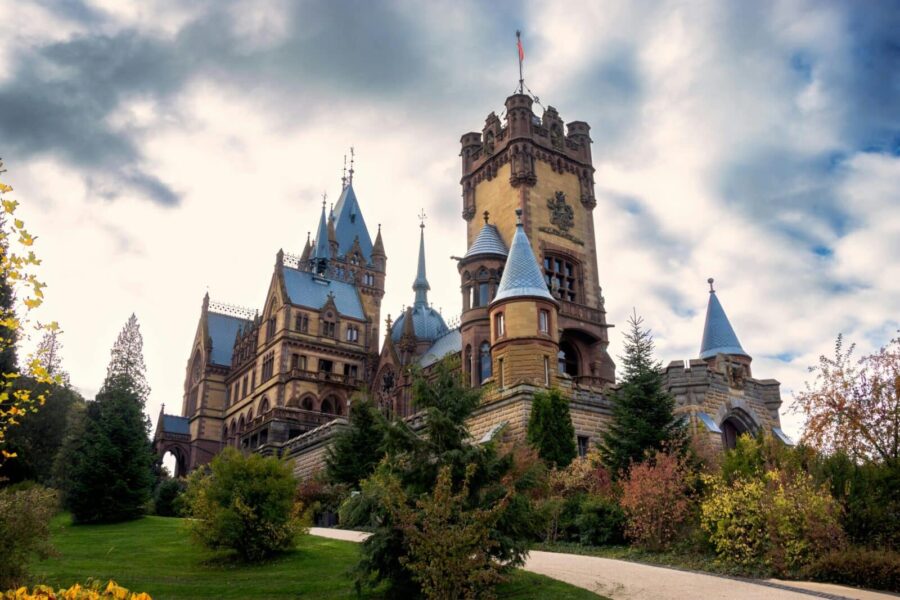Schloss Drachenburg in Königswinter, Germany, under a vibrant autumn sky.