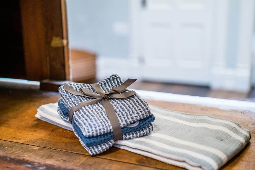 Close-up of rustic linen towels neatly stacked on a wooden surface indoors.