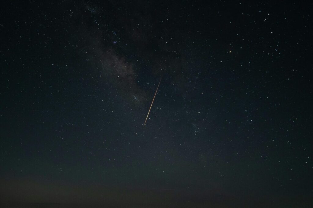 Beautiful night sky showcasing a shooting star against the Milky Way galaxy.