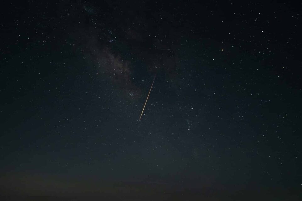 Beautiful night sky showcasing a shooting star against the Milky Way galaxy.