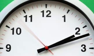 A close-up image of an analog clock face showing time with blurred motion