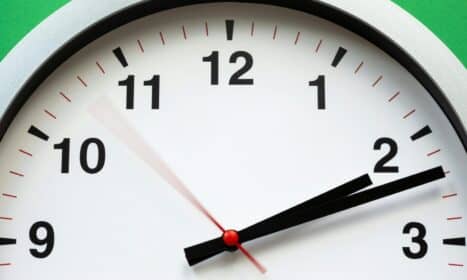 A close-up image of an analog clock face showing time with blurred motion