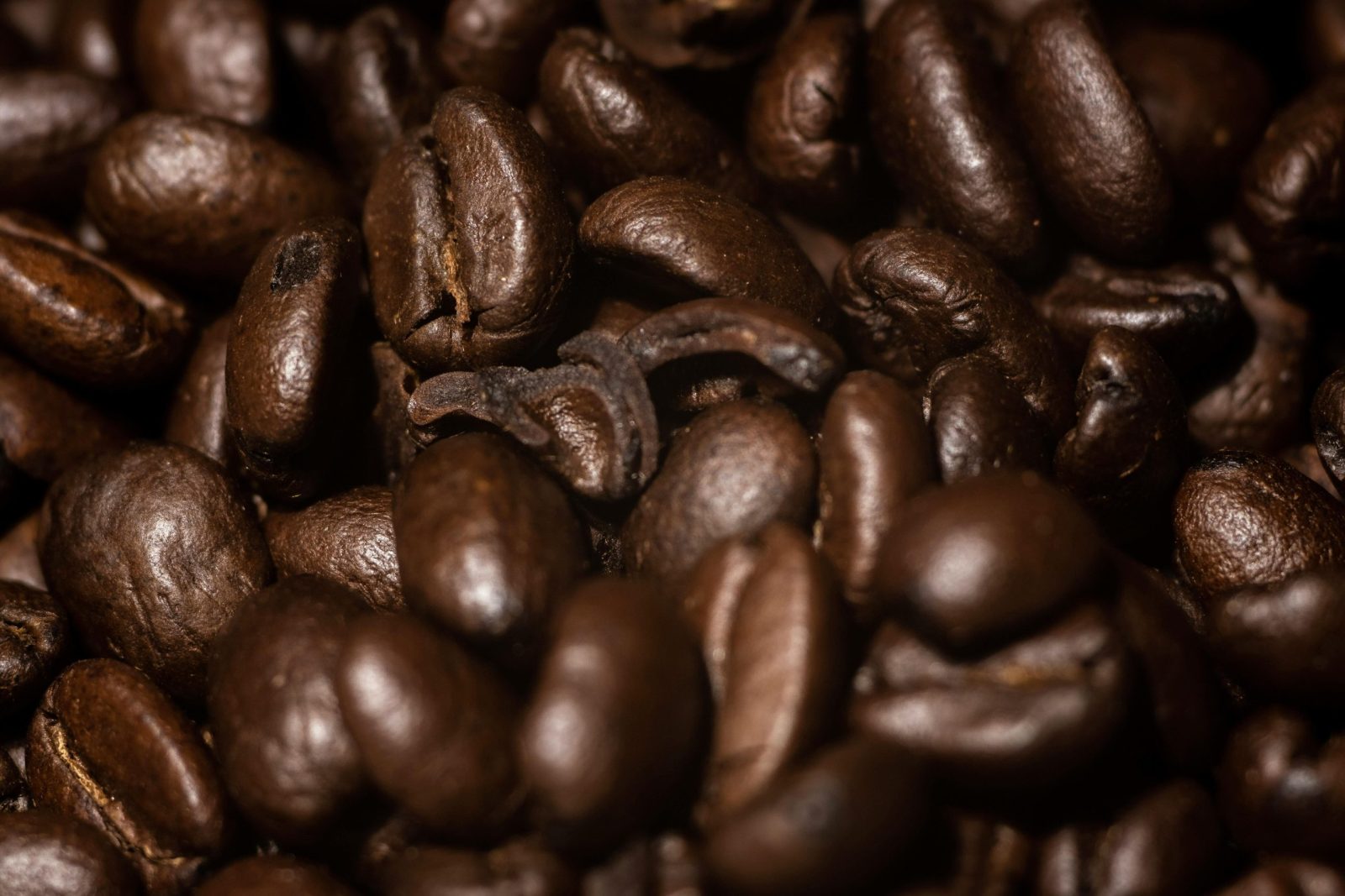 Detailed close-up of aromatic roasted coffee beans, capturing rich textures and deep brown hues.