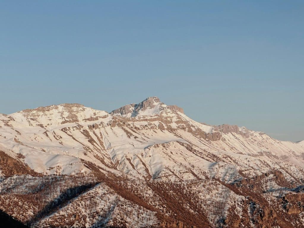 Majestic view of snowcapped mountains in Warte, Erbil Governorate, Iraq under clear blue skies.