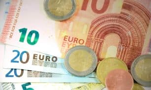 Detailed shot of Euro banknotes and coins showcasing currency denominations.