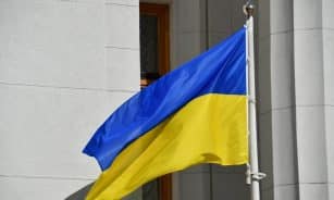 Ukrainian national flag waving outside a Kiev government building, symbolizing patriotism.