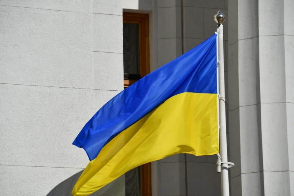 Ukrainian national flag waving outside a Kiev government building, symbolizing patriotism.