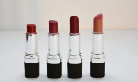 Four different shades of lipsticks arranged neatly, perfect for beauty content.