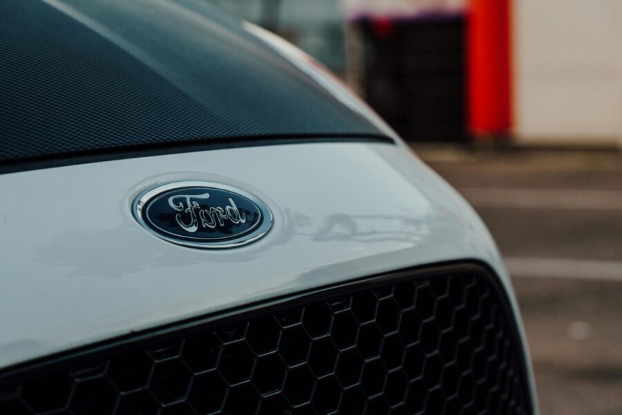Detailed close-up image showcasing a white Ford car emblem on the vehicle's grille.