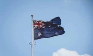 Australian national flag waving on a flagpole against a clear blue sky in Perth.