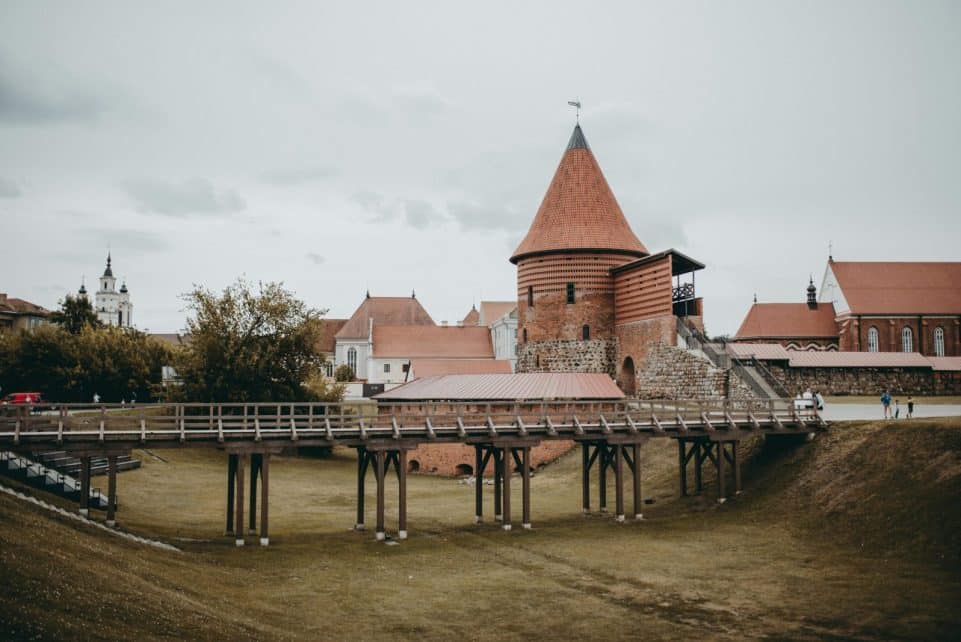 View of the historic Kaunas Castle with its distinctive red brick towers and wooden bridge.