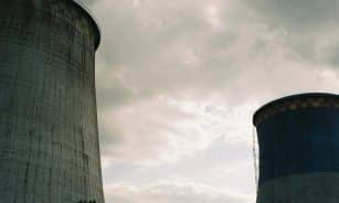 Imposing cooling towers of a nuclear power station under a cloudy sky, showcasing industrial architecture.