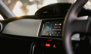 Close-up of a car's digital dashboard featuring music and time display.