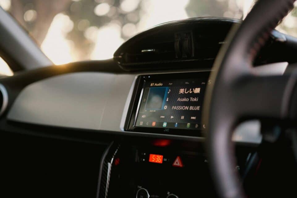 Close-up of a car's digital dashboard featuring music and time display.