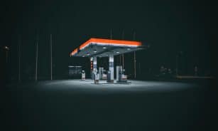 An isolated and illuminated gas station at night, highlighting urban solitude under a dark sky.