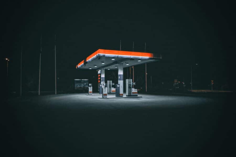 An isolated and illuminated gas station at night, highlighting urban solitude under a dark sky.