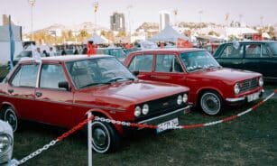 Classic Fiat cars showcased during a lively Turkish car exhibition outdoors.