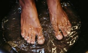 Close-up of male feet soaking in water for a relaxing spa treatment.