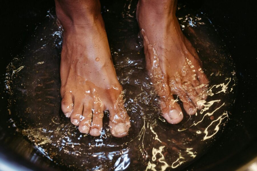 Close-up of male feet soaking in water for a relaxing spa treatment.
