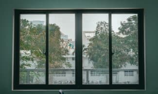 Serene view through a large window of an urban classroom, featuring trees and cityscape.