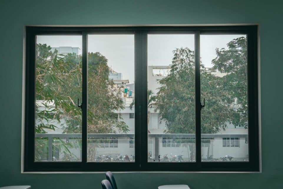 Serene view through a large window of an urban classroom, featuring trees and cityscape.