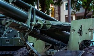 Detailed view of military artillery equipment displayed outdoors in a museum setting.