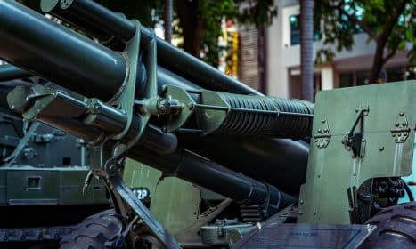 Detailed view of military artillery equipment displayed outdoors in a museum setting.