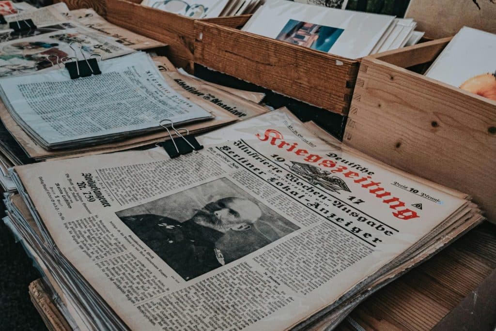 Retro German newspapers featuring historical portraits in wooden boxes, evoking a vintage aesthetic.