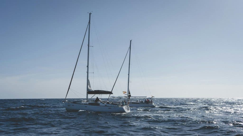 Two sailboats sailing on the Atlantic near Santa Cruz de Tenerife under a clear blue sky.