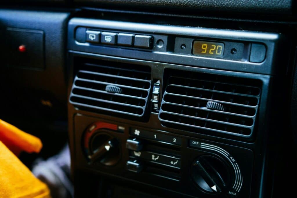 Detailed view of a car's dashboard featuring control knobs and a digital clock display.