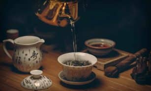 Artistic depiction of a traditional Chinese tea ceremony with porcelain teaware and hot water pour.